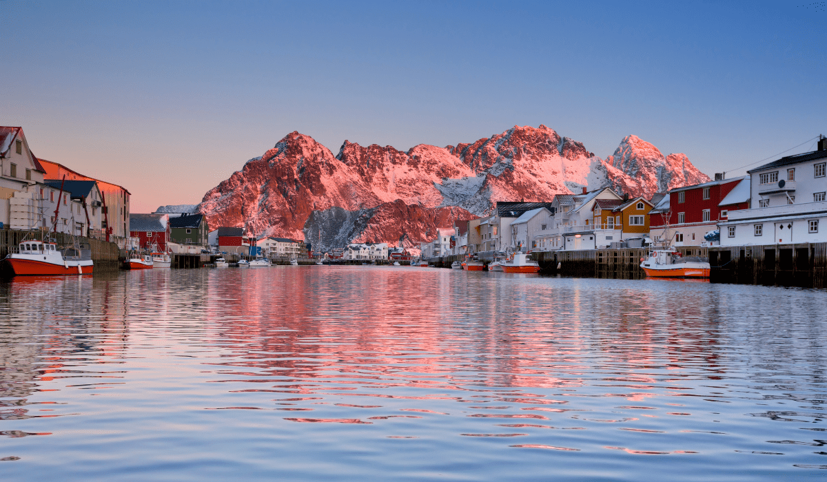 Explore charming Henningsvær village with their traditional red-and-white cottages
