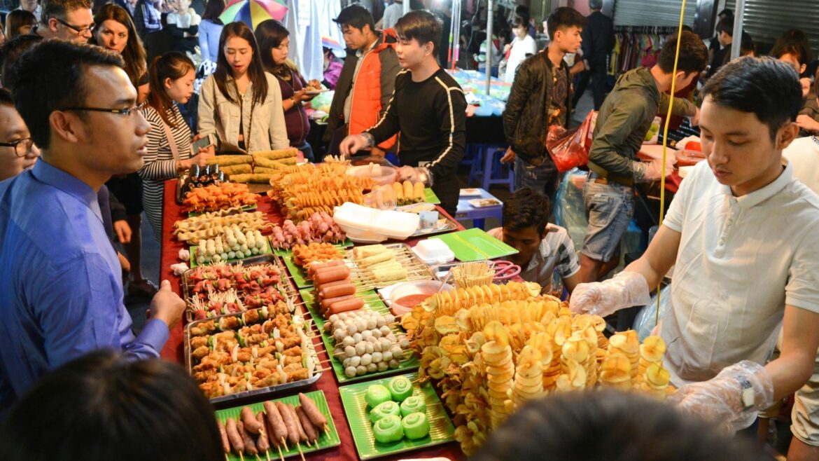 People enjoy treet food at night market, Hanoi, Vietnam, included in tours offered by Asia Vacation Group